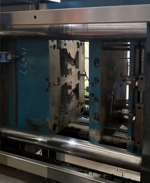Two-shot injection mold with rotating core and power tool housing cavities