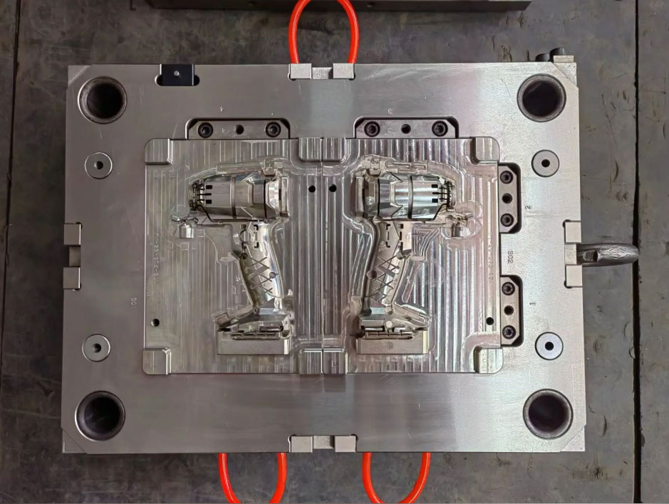Two-shot injection mold with rotating core and power tool housing cavities